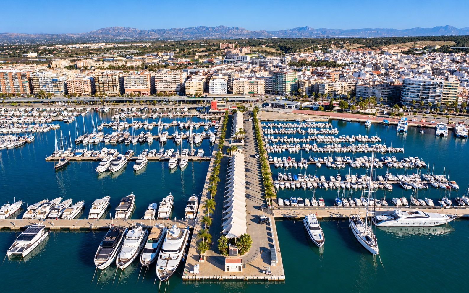Aerial view of a marina with pontoons, moored boats and a travel lift